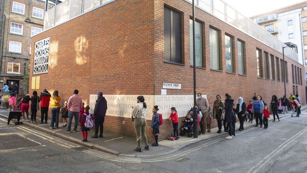 Pupils and parents queue on the first day back to school at Charles Dickens Primary School in London, Tuesday Sept. 1, 2020. Hundreds of thousands of British schoolchildren are heading back to classrooms, with the country watching nervously to see if reopening schools brings a surge in coronavirus infections. Tuesday marks the start of term for about 40% of schools in England and Wales, with the rest reopening in the coming days.  - Sputnik International