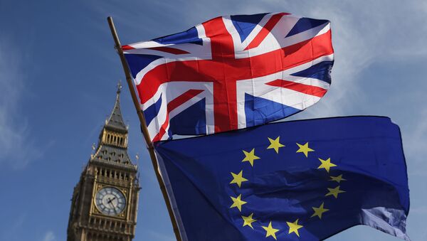 In this file picture taken on March 25, 2017 an EU flag and a Union flag held by a demonstrator is seen with Elizabeth Tower (Big Ben) and the Houses of Parliament as marchers taking part in an anti-Brexit, pro-European Union (EU) enter Parliament Square in central London, ahead of the British government's planned triggering of Article 50 next week. - Sputnik International