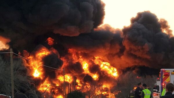 A fire is seen at the place of the train and truck collision in Cameron, Texas, U.S., February 23, 2021, in this still image obtained from a social media video. - Sputnik International