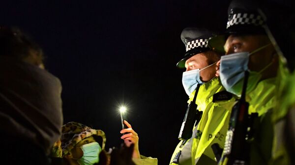Mourners face police officers at a memorial site at the Clapham Common Bandstand, following the kidnap and murder of Sarah Everard, in London, Britain - Sputnik International