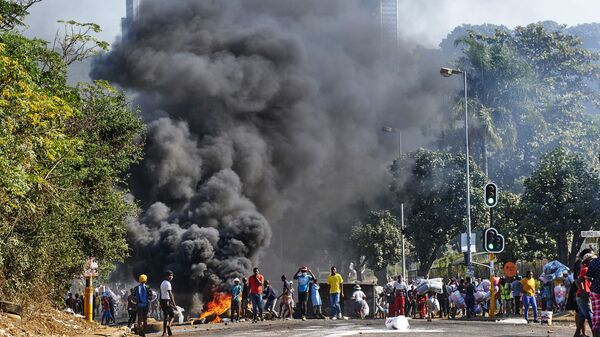 Looters outside a shopping centre alongside a burning barricade in Durban, South Africa, Monday July 12, 2021 - Sputnik International