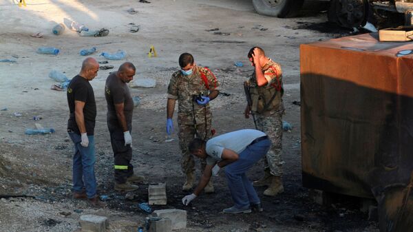Civil defense members and army soldiers inspect the site of a fuel tank explosion in Akkar, in northern Lebanon, August 15, 2021 - Sputnik International