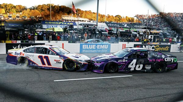 Denny Hamlin (11) prevents Alex Bowman (48) from doing a celebratory burnout after a NASCAR Cup Series auto race, Sunday, Oct. 31, 2021, in Martinsville, Va. - Sputnik International