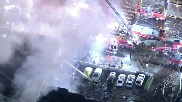Screenshot captures members of the Los Angeles Fire Department collectively working to extinguish a massive blaze in Koreatown. Approximately 103 firefighters were reported as being on site. - Sputnik International