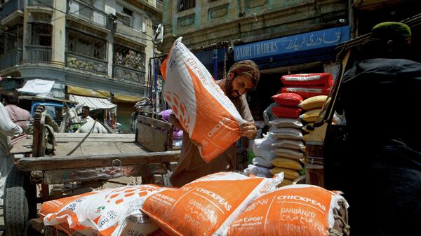 A laborer unload sacks of chickpeas at a market in Karachi, Pakistan, Thursday, July 14, 2022. - Sputnik International