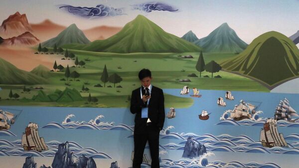 A man stands near ]a mural depicting the ancient Silk Road during the Second Belt and Road Forum In Beijing on Friday, April 26, 2019 - Sputnik International