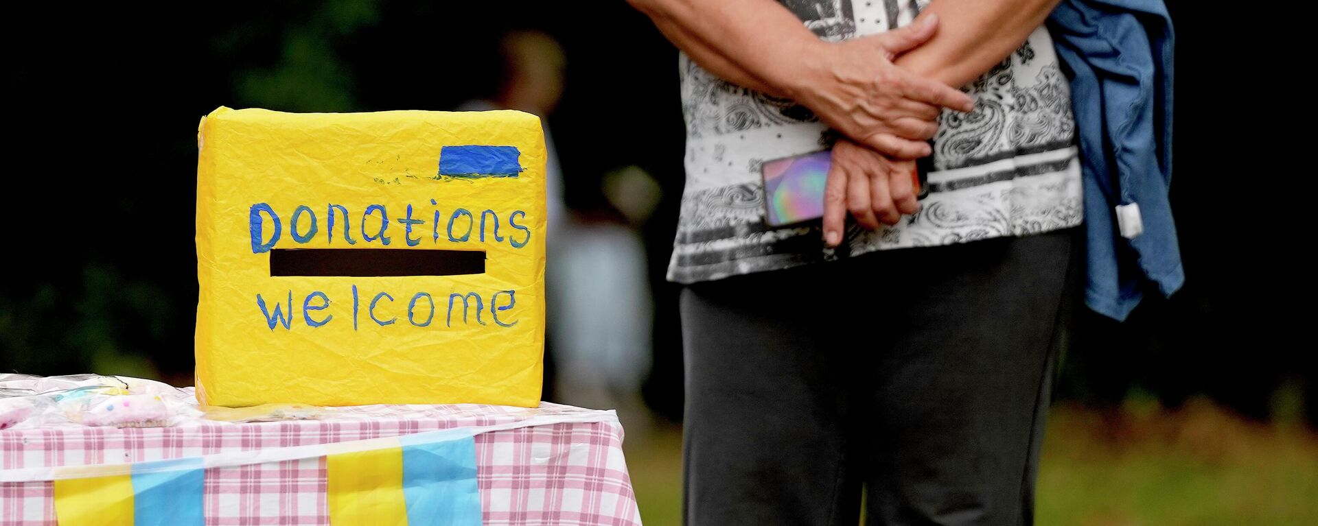 A woman waits near a donation box at the celebration for the Ukraine Independence day at a celebration in Chichester, south England, Saturday, Aug. 27, 2022 A woman waits near a donation box at the celebration for the Ukraine Independence day at a celebration in Chichester, south England, Saturday, Aug. 27, 2022 - Sputnik International, 1920, 22.10.2022