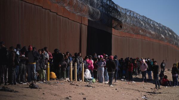 Hundreds of migrants line up to be processed by THE US Border Patrol under the Stanton Street Bridge after illegally entering the US, in El Paso, Texas, on December 22, 2022 - Sputnik International