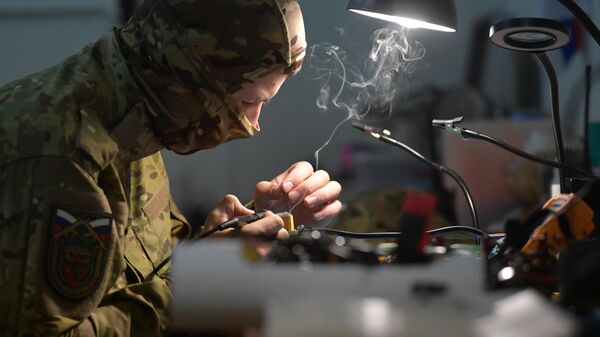 A drone pilot assembles drones at a facility  - Sputnik International