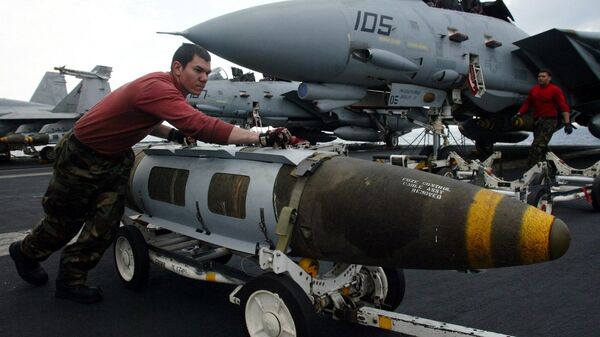 An Ordnance pushes a satellite-guided 2000 pound JDAM ( Joint Direct Attac Munitions)  bomb in front of a F-14 Tomcat on the flight deck of the USS Harry S. Truman prior to a strike against Iraq Friday, March 21, 2003 - Sputnik International