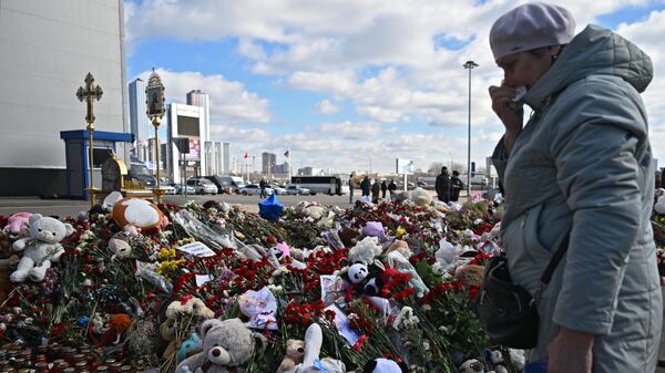 A woman crying at a spontaneous memorial in memory of the victims of the terrorist attack in Crocus City Hall. - Sputnik International