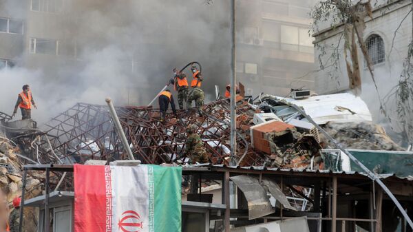Emergency and security personnel extinguish a fire at the site of strikes which hit a building annexed to the Iranian embassy in Syria's capital Damascus, on April 1, 2024. - Sputnik International