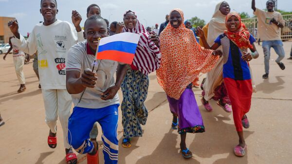 Nigeriens hold a Russian flag in Niamey, Niger, Sunday, Aug. 6, 2023. - Sputnik International