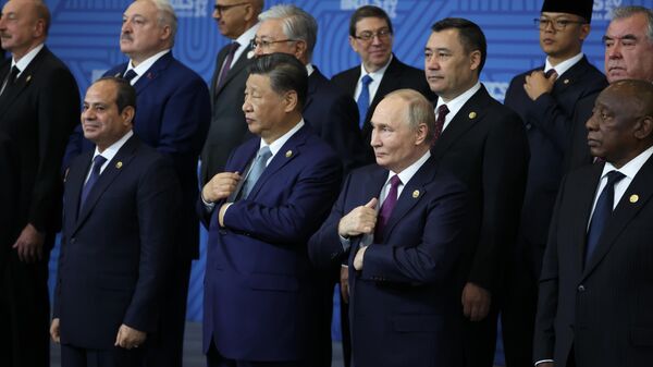 Russian President Vladimir Putin, Chinese President Xi Jinping and other attendees of the BRICS Summit in Kazan pose for a group photo. - Sputnik International