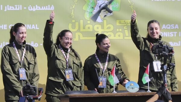 Israeli female soldier hostages wave and react at a Palestinian crowd before being handed over to the Red Cross in Gaza City, Saturday, Jan. 25, 2025.  - Sputnik International