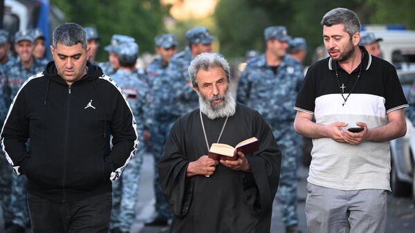 Priest Grigor Hovhannisyan reads a prayer outside a courthouse in Yerevan. A criminal case has been opened against Archbishop of Shirak of the Armenian Apostolic Church Mikael Ajapakhian, who is accused of publicly calling for the seizure of power, violation of territorial integrity, renunciation of sovereignty and violent overthrow of the constitutional order. On the night of June 28, Mikael Ajapakhian was arrested by a court decision for two months.
 - Sputnik International