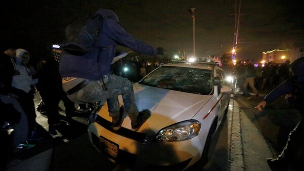 Protesters vandalize a police car outside the Ferguson Police Department in Ferguson, Missouri, after a grand jury returned no indictment in the shooting of Michael Brown - Sputnik International