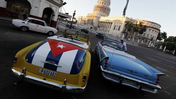 A car with a Cuban flag is parked near Cuban Capitol in Havana December 18, 2014. Cuban President Raul Castro hailed a landmark exchange of prisoners with the United States on Wednesday and praised U.S. President Barack Obama as the two countries agreed to normalize relations after more than five decades of hostility - Sputnik International
