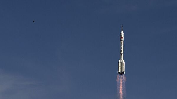 The Long March 2F rocket carrying the Shenzhou 10 capsule blasts off from the Jiuquan Satellite Launch Center as a bird flies, in Jiuquan, northwest China's Gansu Province - Sputnik International