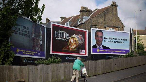 A woman walks past a UK Independence Party (UKIP) election poster showing their leader Nigel Farage in Ramsgate, south east England, Thursday, May 7, 2015 - Sputnik International