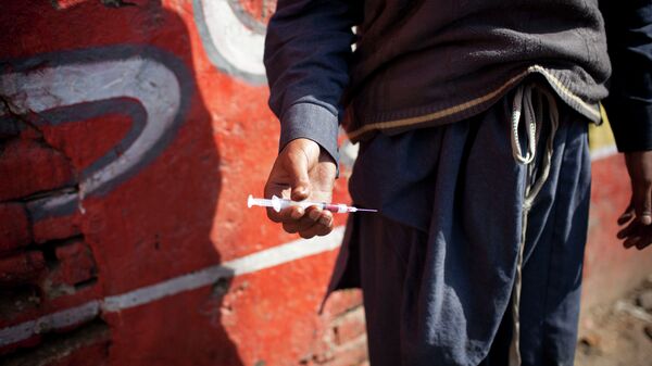 A drug addict holds a needle and syringe. - Sputnik International
