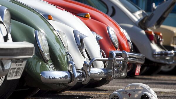 A Volkswagen Beetle toy is seen in front of Beetle cars during celebrations of the National day of the Beetle in Sao Bernardo do Campo in 2011. - Sputnik International