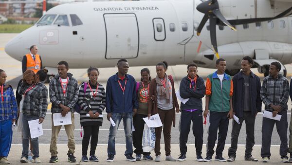 Eritrean refugee pose for a group photo in front of an Italian Financial police aircraft which will take them to Sweden, at Rome's Ciampino airport, Friday, Oct. 9, 2015. - Sputnik International