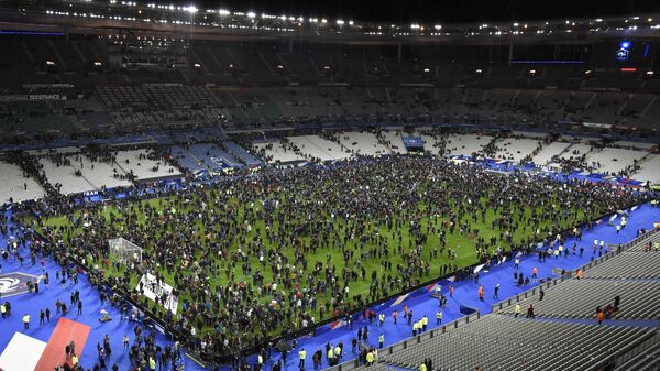 Spectators gather on the pitch of the Stade de France stadium following the friendly football match between France and Germany in Saint-Denis, north of Paris, on November 13, 2015, after a series of gun attacks occurred across Paris as well as explosions outside the national stadium where France was hosting Germany - Sputnik International