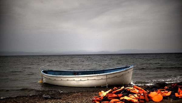 Life jackets and a boat that were used by refugees and migrants to cross the Aegean sea from Turkey lie abandoned on a beach on the Greek Island of Lesbos on October 8, 2015. - Sputnik International
