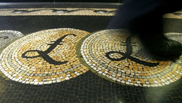 An employee is seen walking over a mosaic of pound sterling symbols set in the floor of the front hall of the Bank of England in London, in this March 25, 2008 file photograph.  - Sputnik International