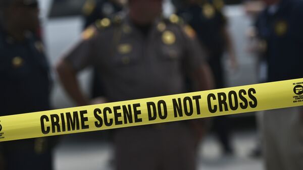 Police stand behind a crime scene tape near the mass shooting at the Pulse nightclub on in Orlando, Florida on June 12, 2016. - Sputnik International
