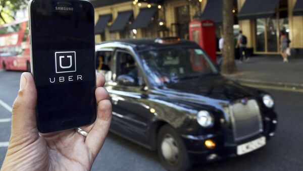 A photo illustration shows the Uber app logo displayed on a mobile telephone, as it is held up for a posed photograph in central London, Britain August 17, 2016. - Sputnik International