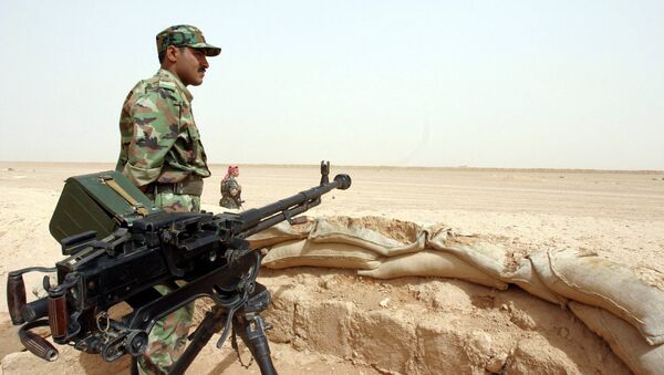 A Syrian soldier stands next to his machingun at a border post in the desert, on the Syrian side of the  border with Iraq (File) - Sputnik International