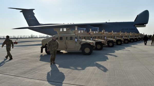Ukrainian servicemen walk in front of armoured cars at Kiev airport on March 25, 2015 during a welcoming ceremony of the first US plane delivery of non-lethal aid, including 10 Humvee vehicles. - Sputnik International