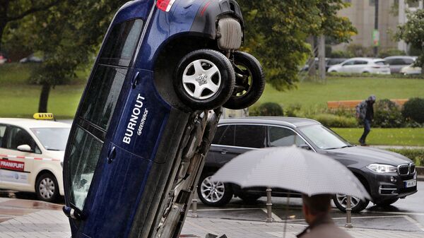 A Volkswagen Touareg stands upside down in front of the fair ground of the IAA Motor Show in Frankfurt, Germany, Wednesday, Sept. 13, 2017. The environmental organization Greenpeace installed the car the day before to protest against the car industry. From frighteningly fast hypercars to new electric SUVs, the Frankfurt auto show is a major event for car lovers wanting to get a glimpse of the future.  - Sputnik International