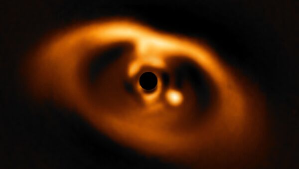 The photo provided by the European Southern Observatory ESO taken from the SPHERE instrument on ESO's Very Large Telescope is the first clear image of a planet caught in the very act of formation around the dwarf star PDS 70. - Sputnik International