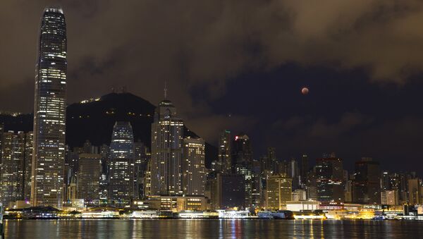 A full moon rises over the Victoria Harbour during a complete lunar eclipse, in Hong Kong, Saturday, July 28, 2018. Skywatchers around much of the world are looking forward to a complete lunar eclipse that will be the longest this century. - Sputnik International