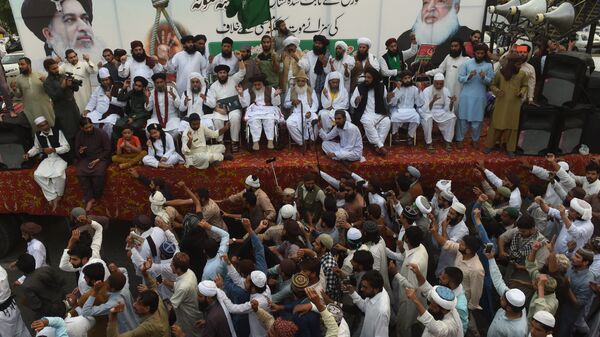 Supporters of Tehreek-e-Labaik Pakistan (TLP), a hardline religious political party, surround their party leader Khadim Hussain Rizvi (C top) during a protest rally in Lahore on October 12, 2018 demanding for hanging to a blasphemy convict Christian woman Asia Bibi, who is on death row. - Sputnik International
