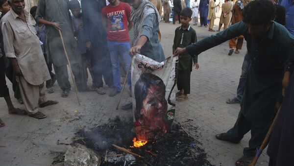 Pakistani protesters burn a poster image of Christian woman Asia Bibi, who has spent eight-years on death row accused of blasphemy and acquitted by a Supreme Court, in Hyderabad, Pakistan, Thursday, Nov. 1, 2018 - Sputnik International