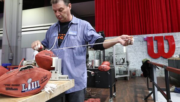 Wilson employee Brad Hanna works on lacing a Super Bowl LIII footballs during the NFL Experience at Georgia World Congress Center. - Sputnik International